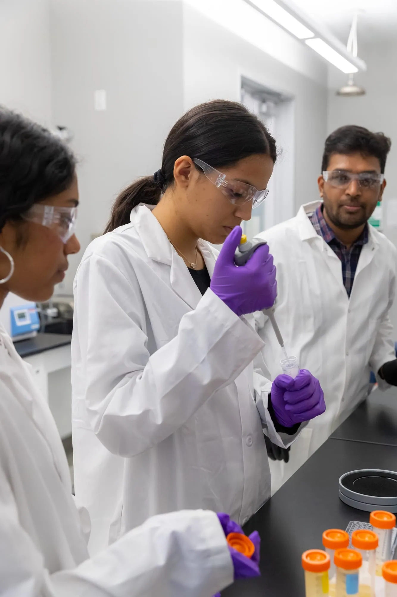 Students in lab coats working together at a lab bench