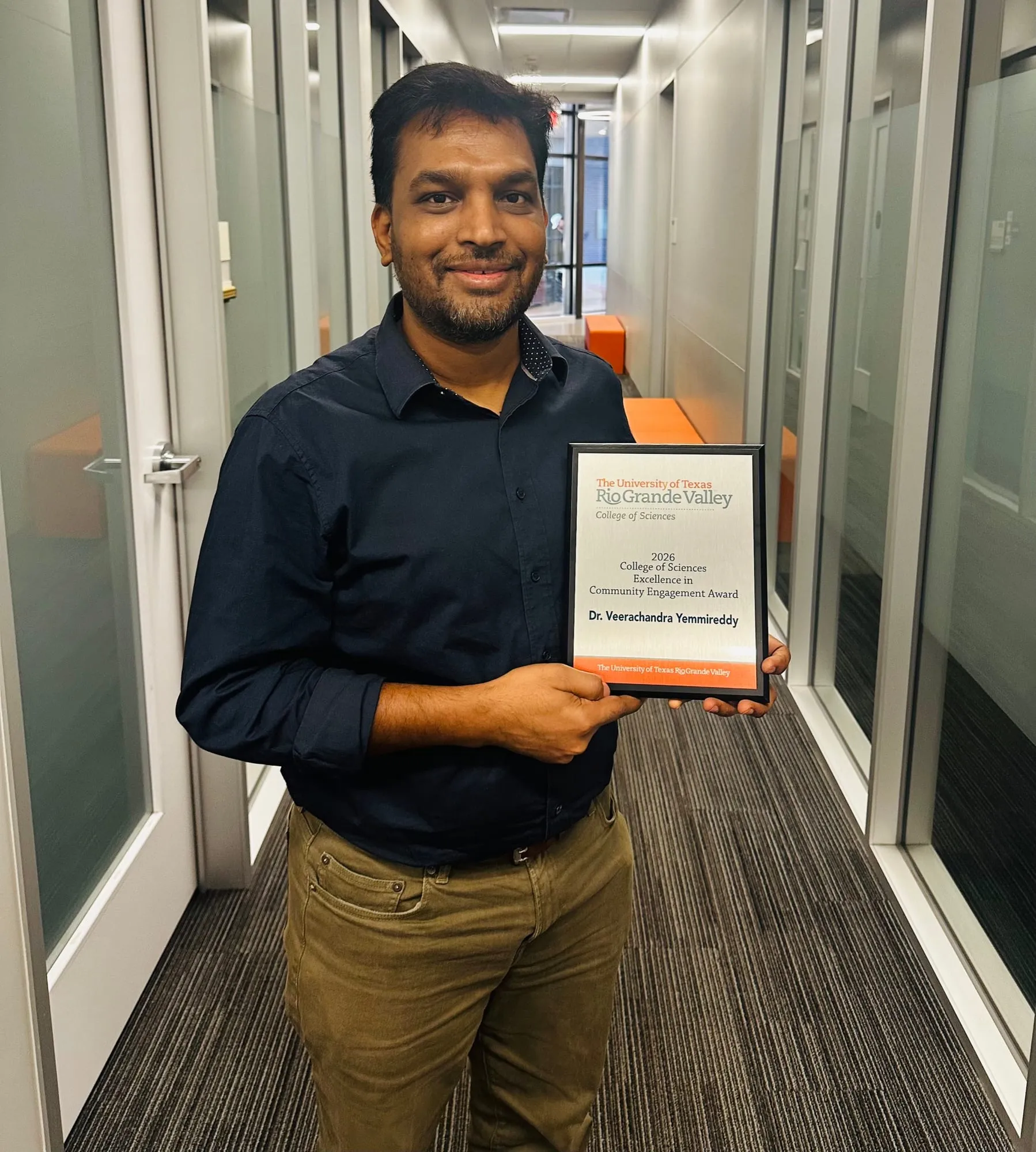 Dr. Yemmireddy holding a certificate of recognition
