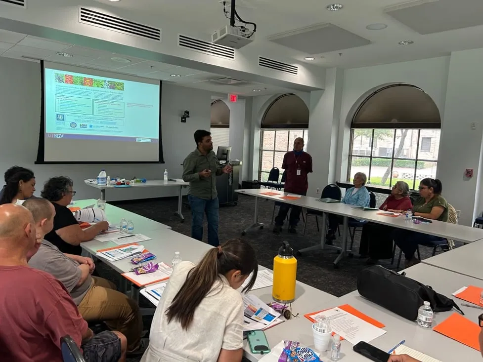 A workshop room with participants and a speaker presenting slides