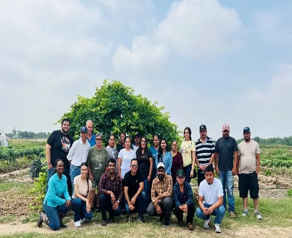 Workshop participants posing for a group photo at a farm