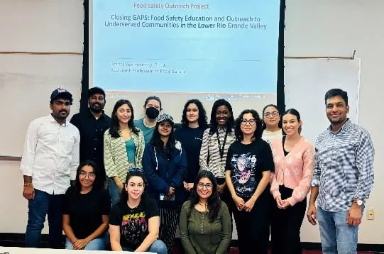 Project team in front of a slide on closing gaps in food safety education for underserved communities in the Lower Rio Grande Valley