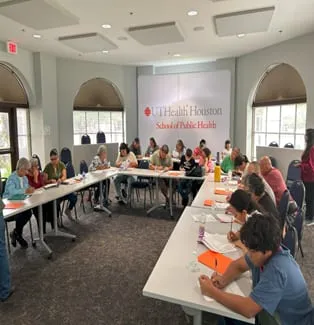 A training room set up with participants at long tables